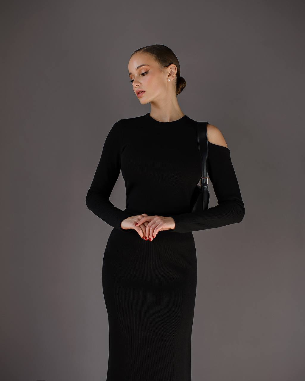 Woman wearing a black dress against a gray background