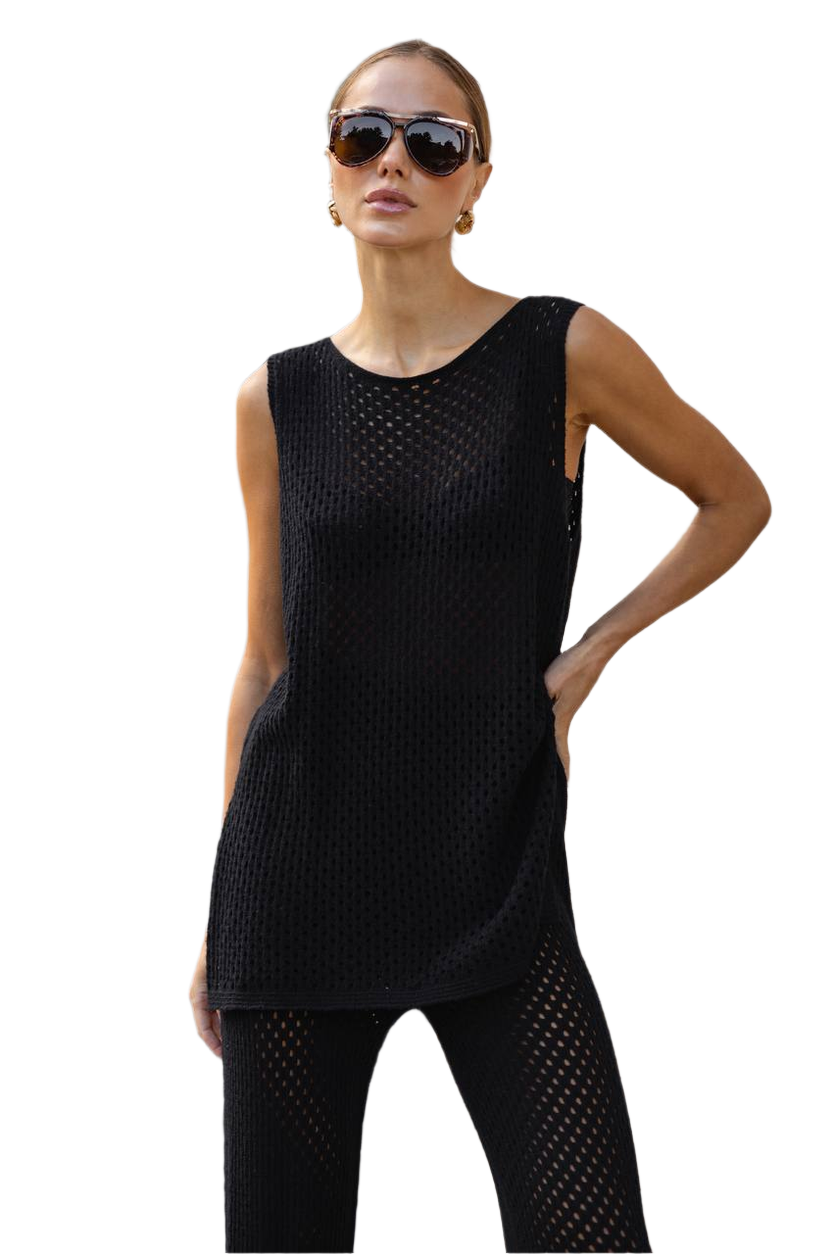 Woman wearing a black sleeveless top and pants on a white background