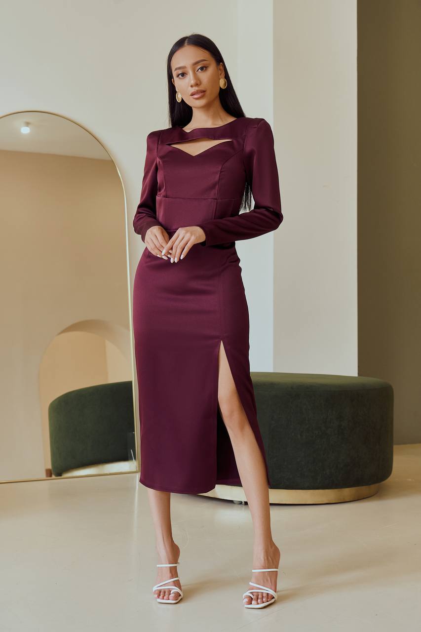 Woman wearing a burgundy dress with a high slit in a modern interior setting