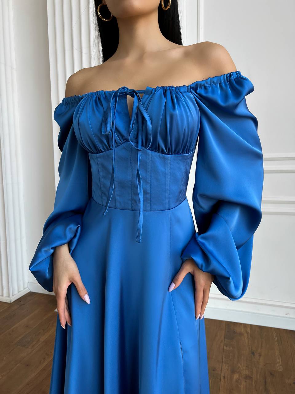 Blue off-shoulder dress with puffed sleeves worn by a person indoors.