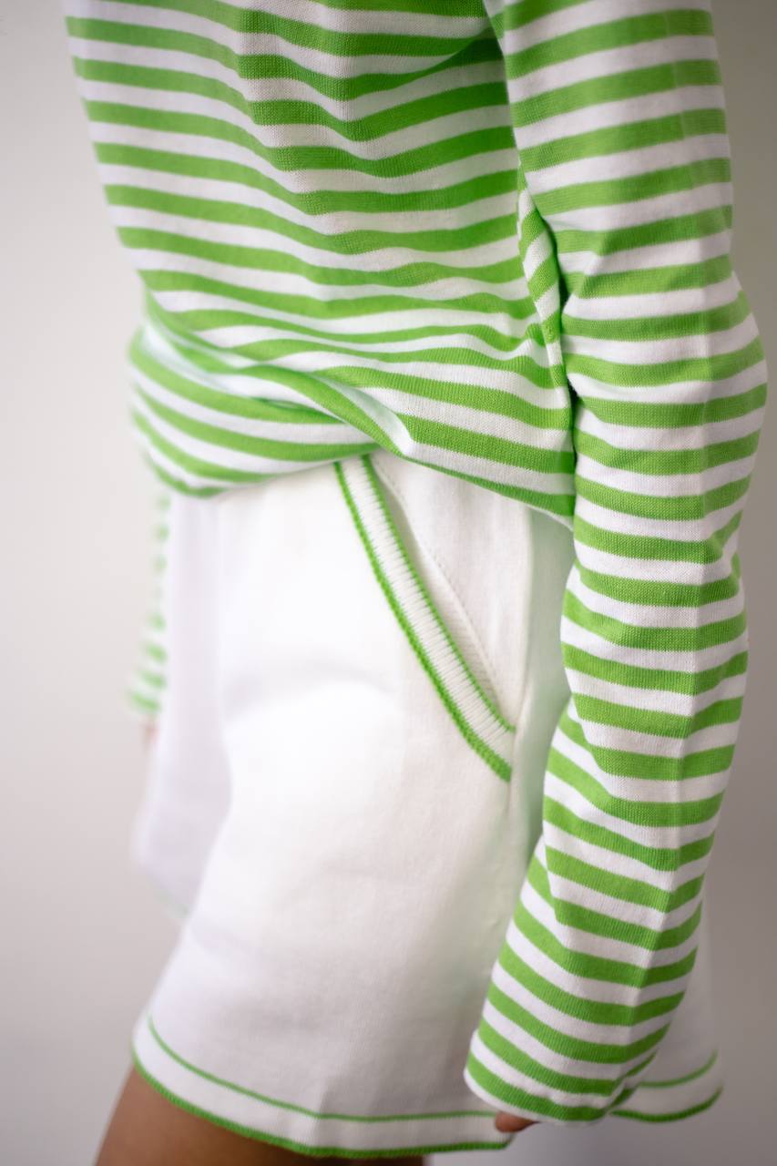 Green and white striped long-sleeve shirt on a plain background