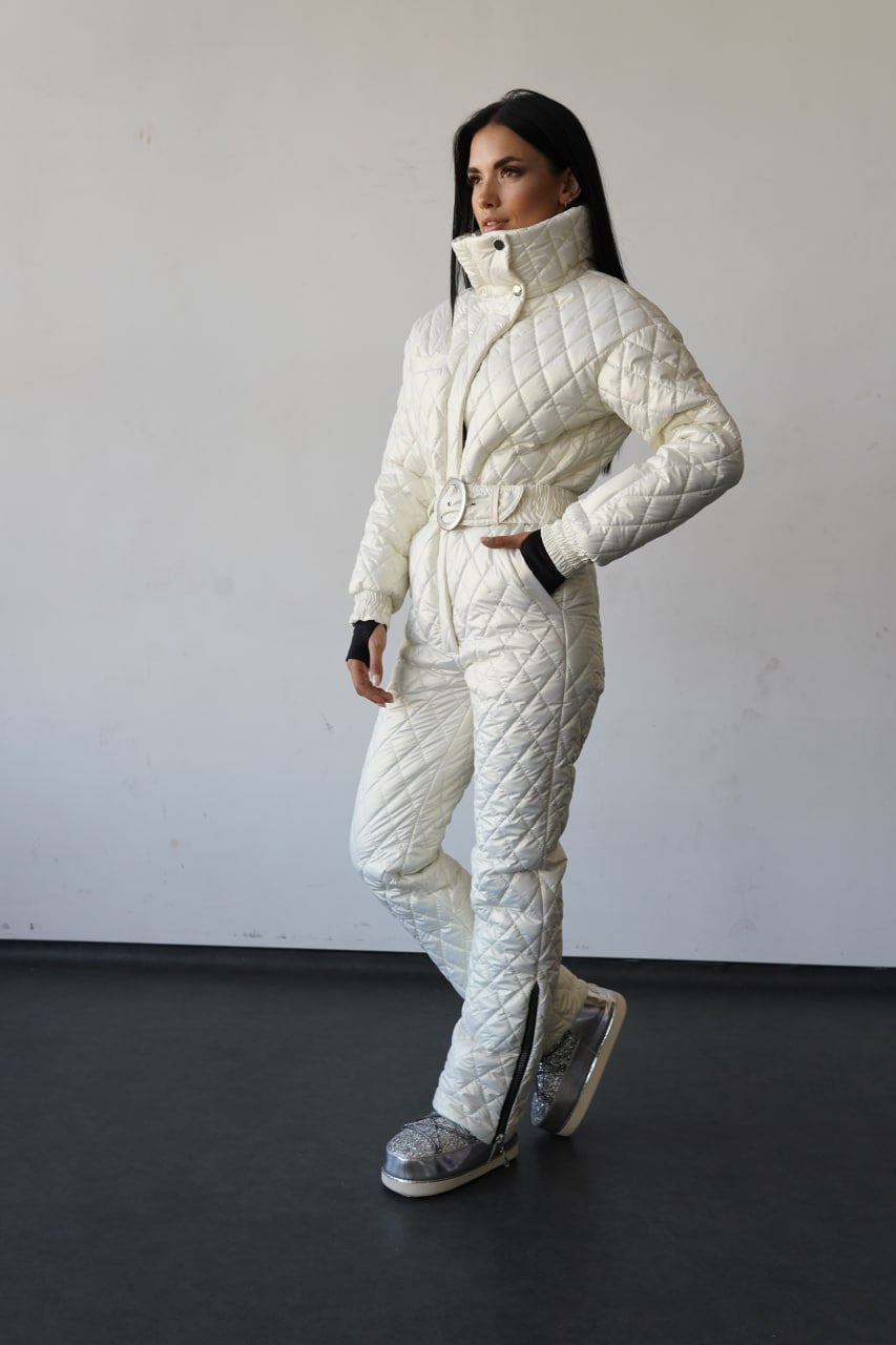 Person wearing a white quilted snowsuit against a plain background