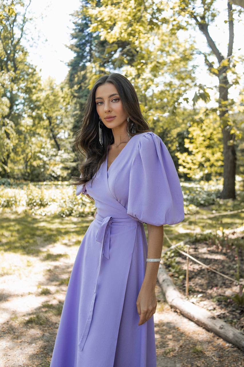 Woman in a purple dress standing in a forest