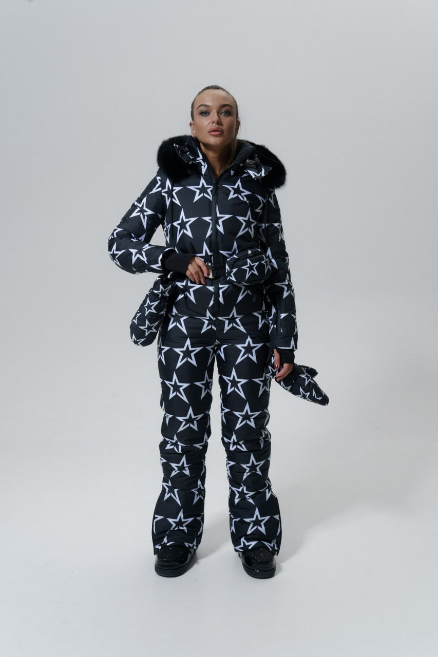 Person wearing a navy blue snowsuit with white star patterns on a white background