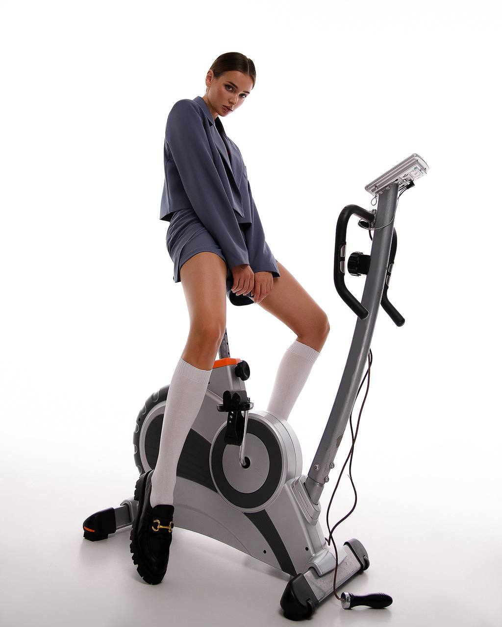 Woman using a stationary bike on a white background
