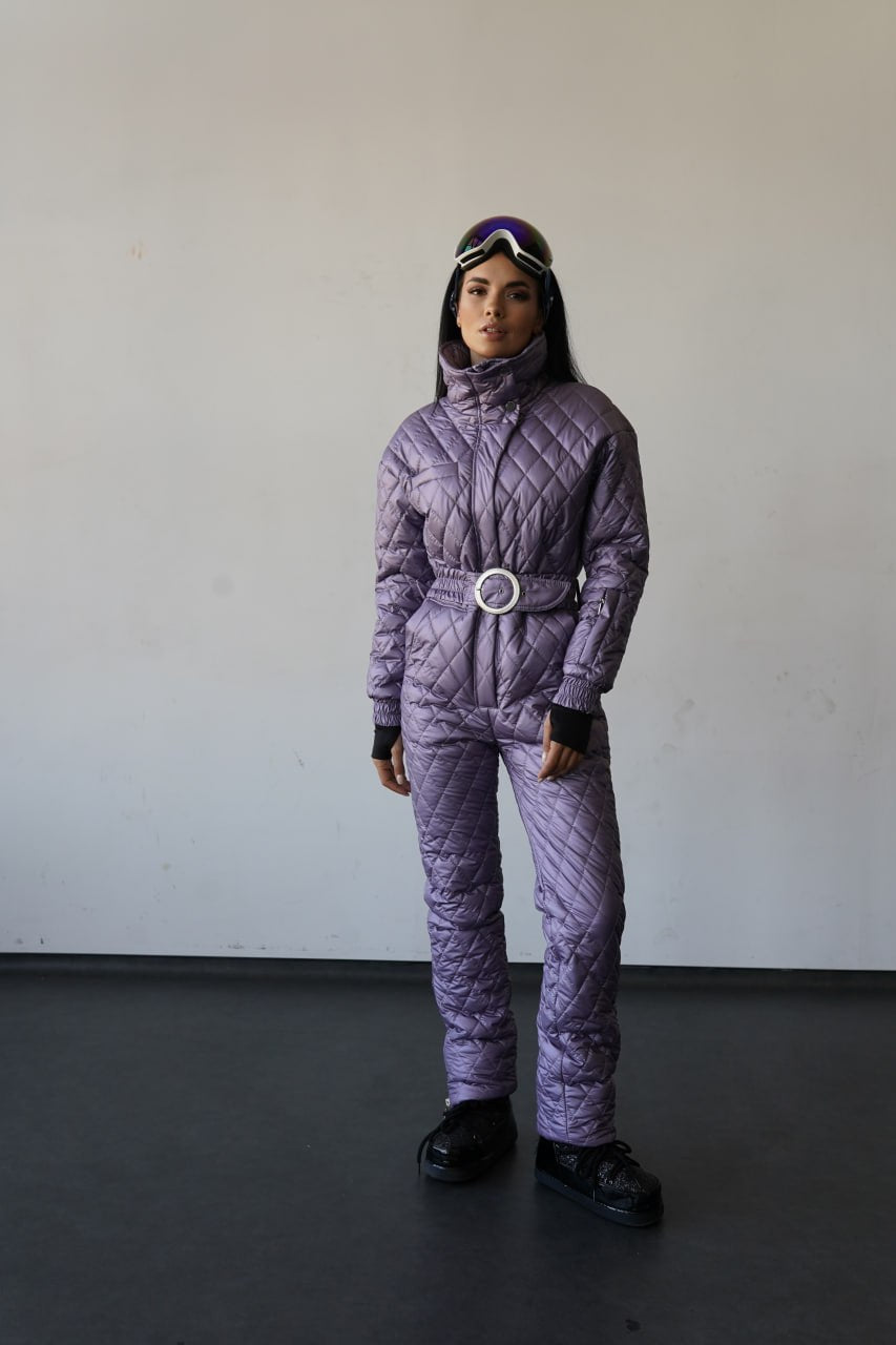Person wearing a purple quilted snowsuit with a belt, standing against a plain background.