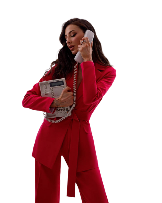 Woman in a red suit holding an old-fashioned telephone on a white background