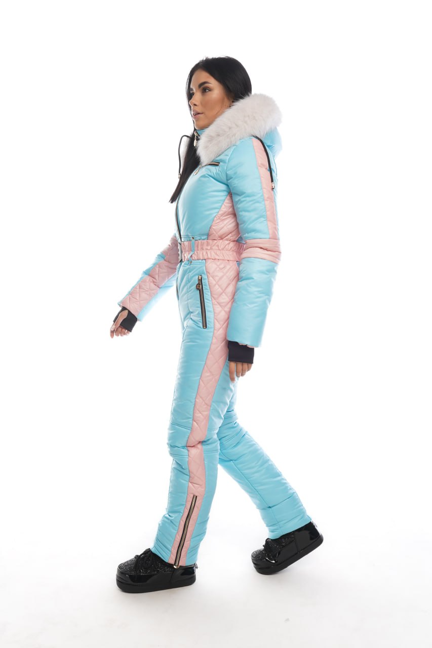 Woman wearing a light blue and pink ski suit on a white background