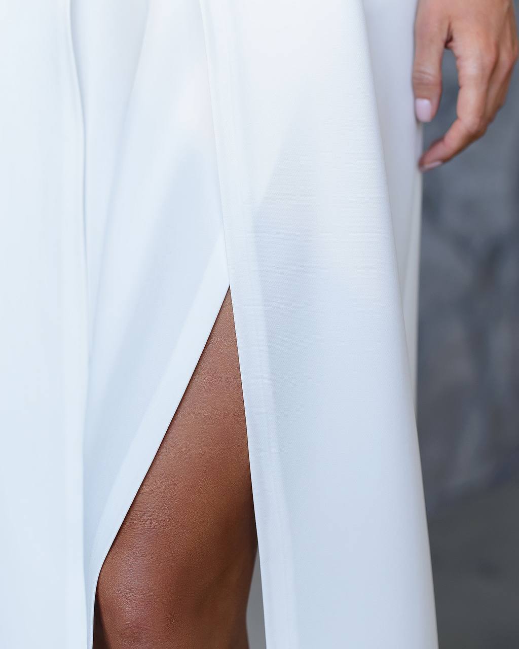 White pants with a high slit on a neutral background