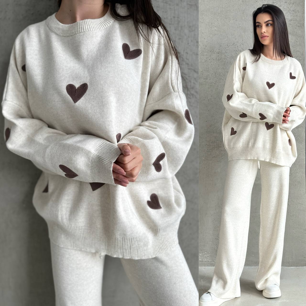 White sweater with brown heart patterns worn by a person against a gray background