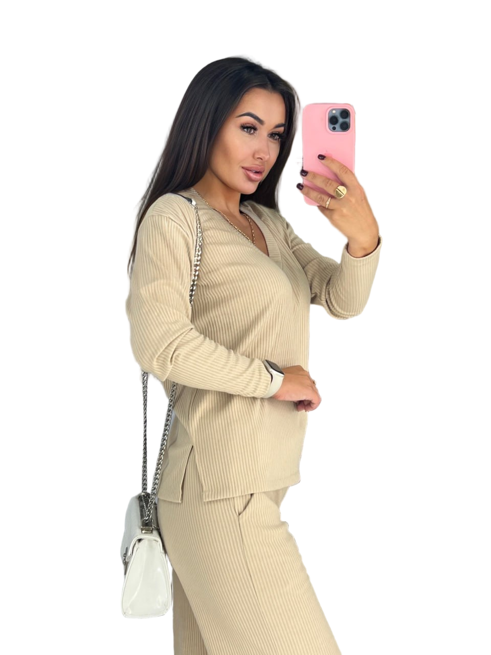 Woman in a beige suit taking a selfie with a pink phone on a white background