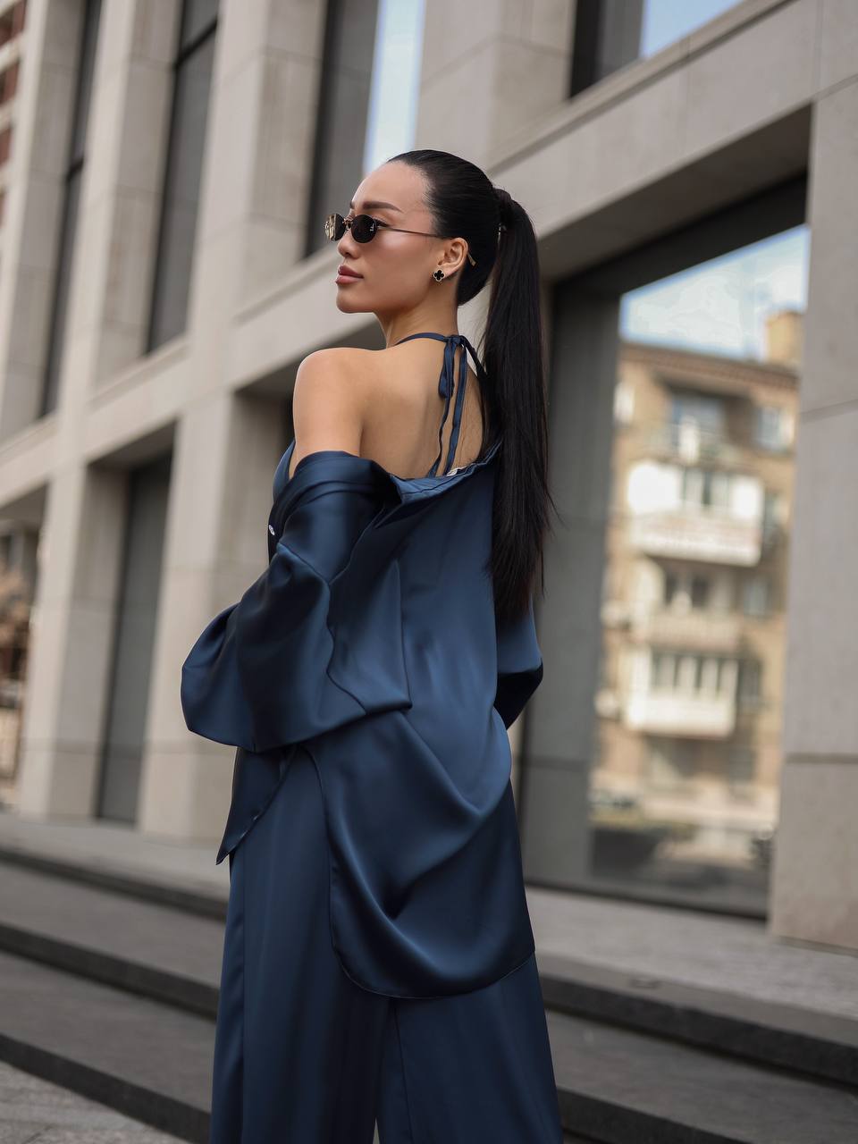 Woman in a blue outfit standing in an urban setting