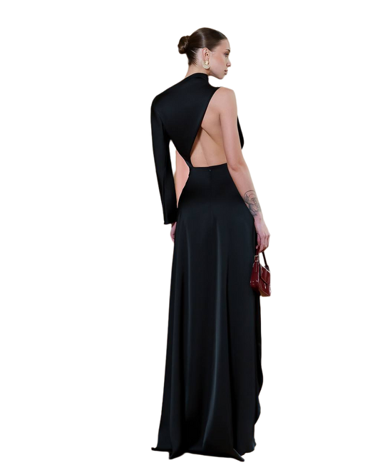 Woman wearing a black evening gown with a high slit on a white background