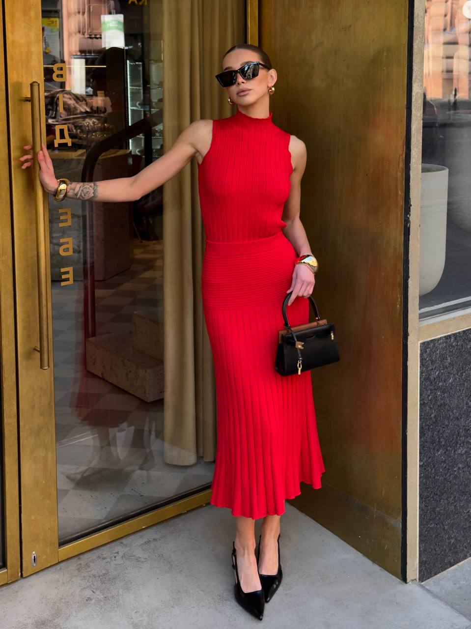 Woman in a red dress standing outside a building