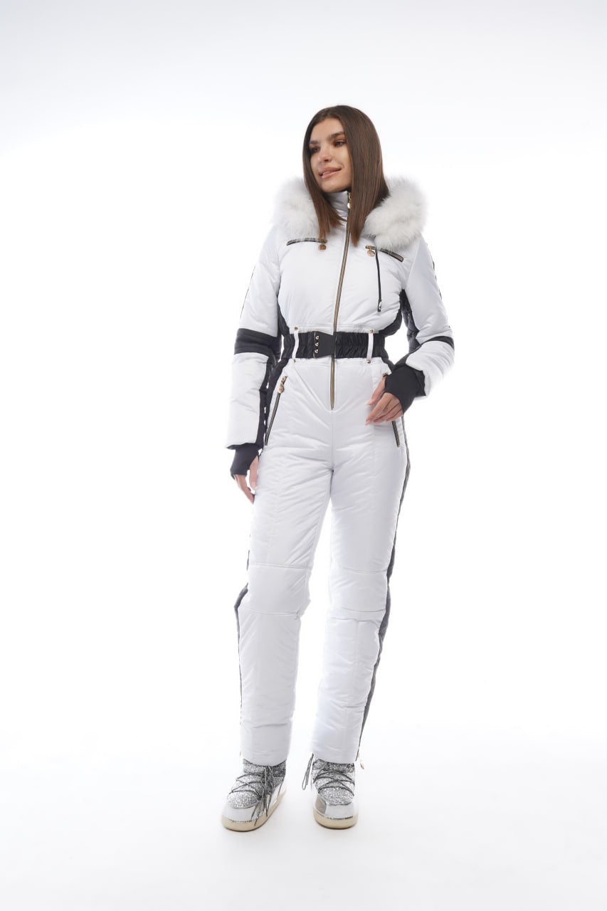 Woman wearing a white snowsuit with black accents on a white background