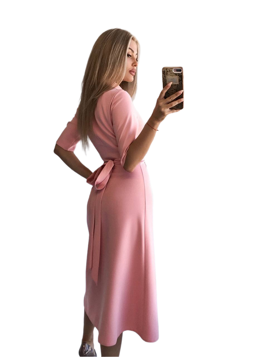 Woman in a pink dress taking a selfie on a white background
