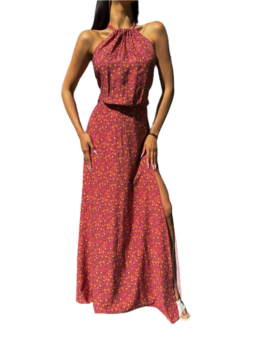 Woman wearing a red floral dress with a slit on a white background