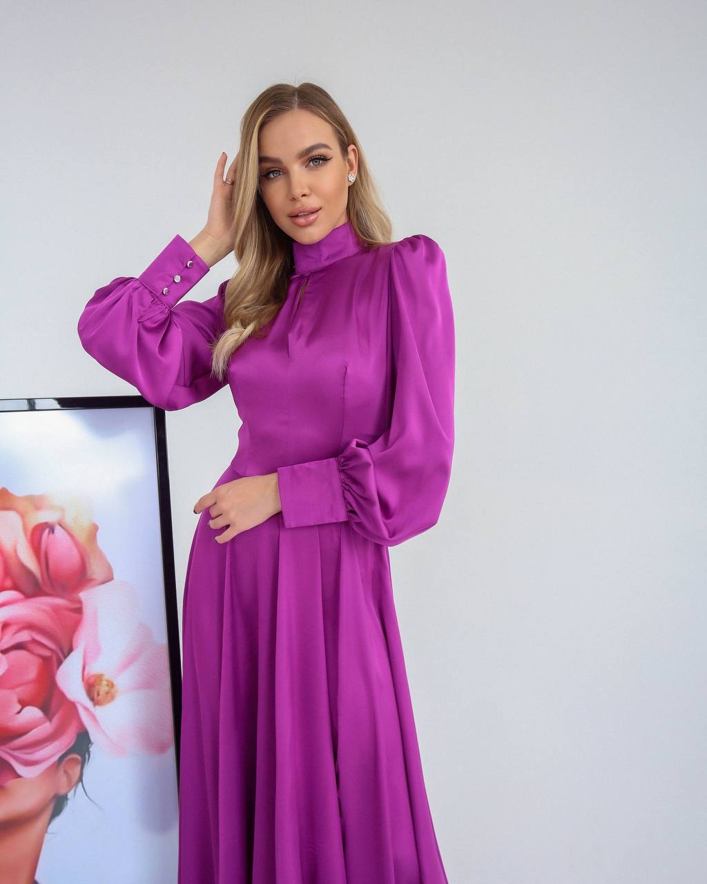 Woman wearing a vibrant purple dress against a plain background
