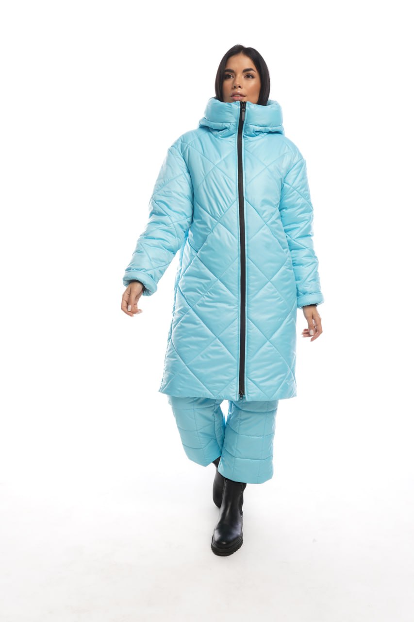 Person wearing a light blue quilted jacket and pants on a white background