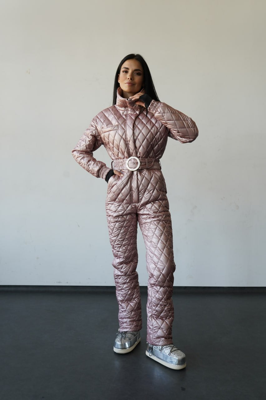 Person wearing a quilted pink snowsuit against a plain background