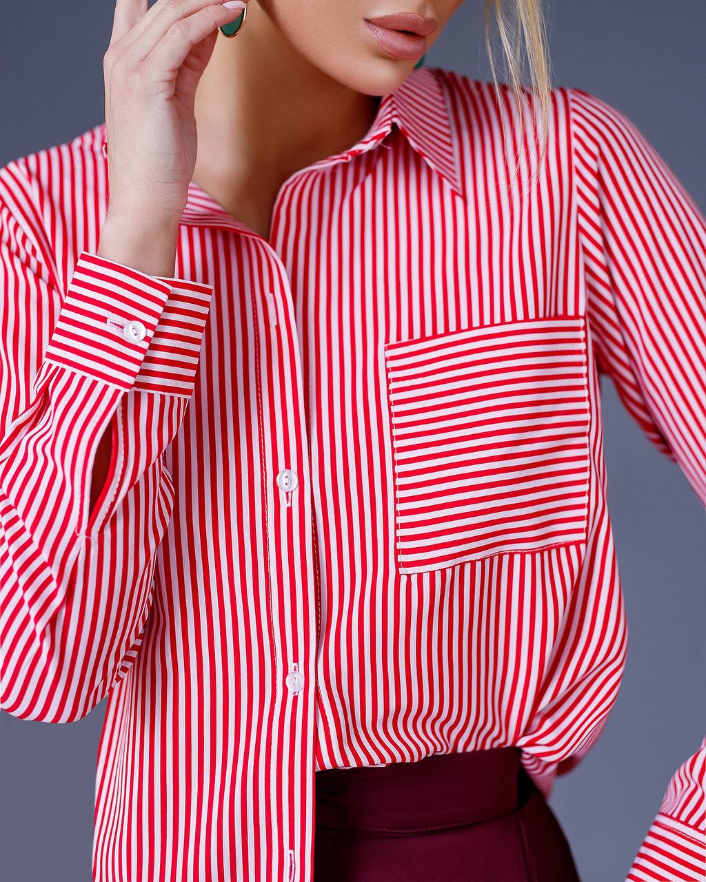Red and white striped shirt worn by a person on a gray background