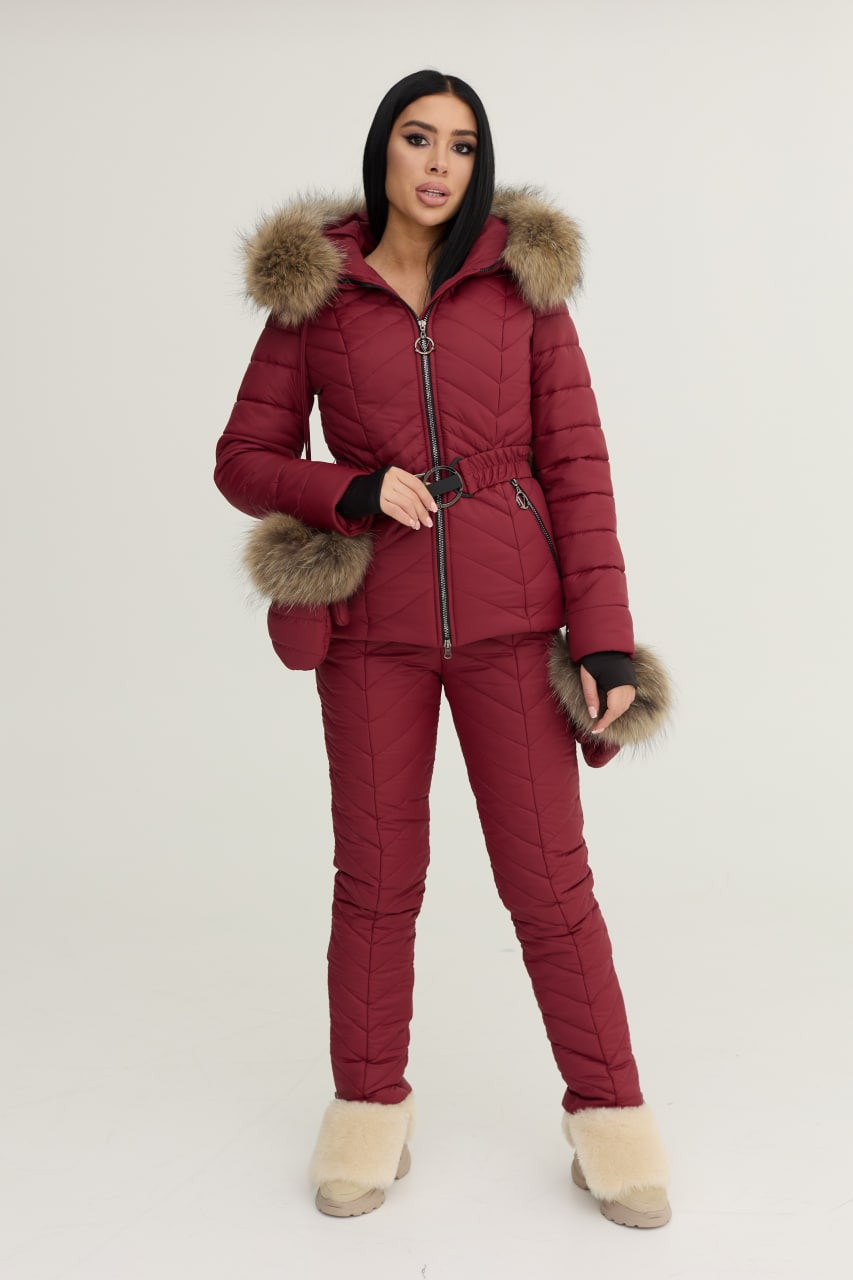 Person wearing a red puffer suit with fur trim on a white background