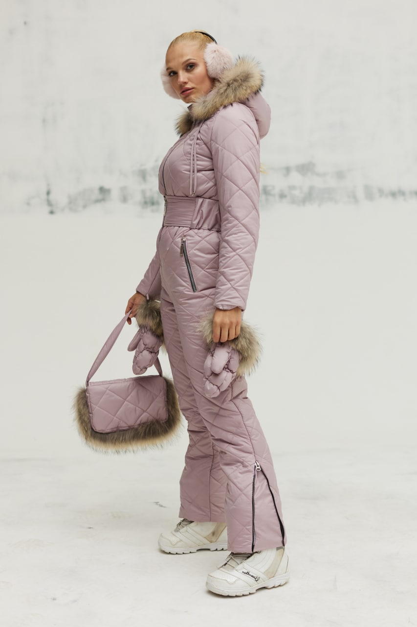 Person wearing a pink winter outfit with fur accents in a snowy background