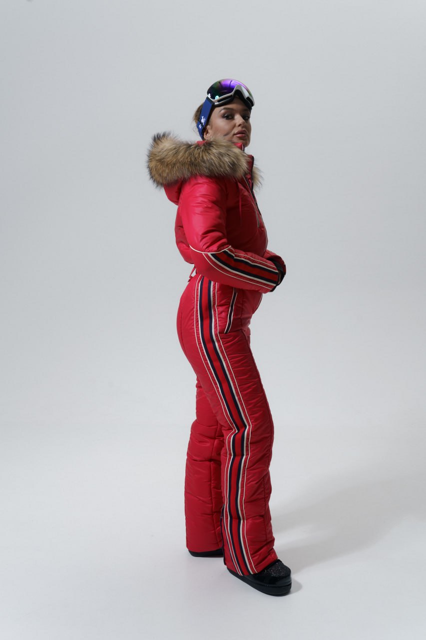 Person wearing a red ski suit with a fur hood on a white background