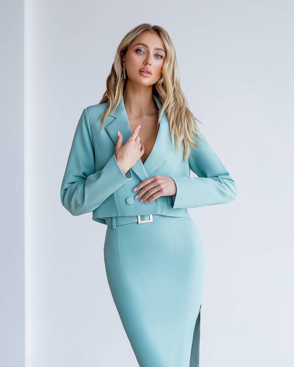 Woman wearing a light blue suit against a white background