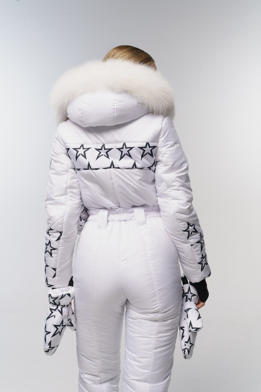 White puffer jacket with star patterns and fur hood on a plain background