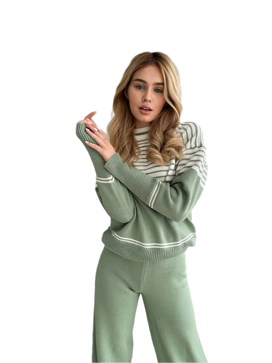 Woman wearing a green and white striped sweater and pants on a white background