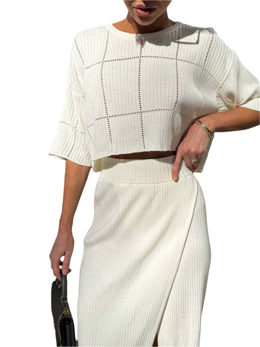 Person wearing a white outfit with a plain background