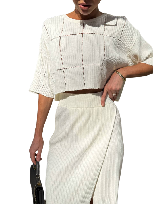 Person wearing a white outfit with a plain background