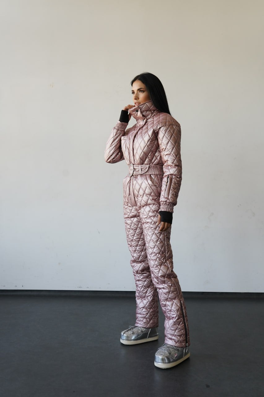 Person wearing a quilted pink snowsuit against a plain background