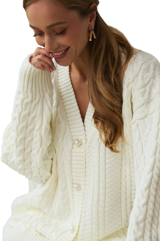 Woman wearing a cream-colored cable knit cardigan on a white background