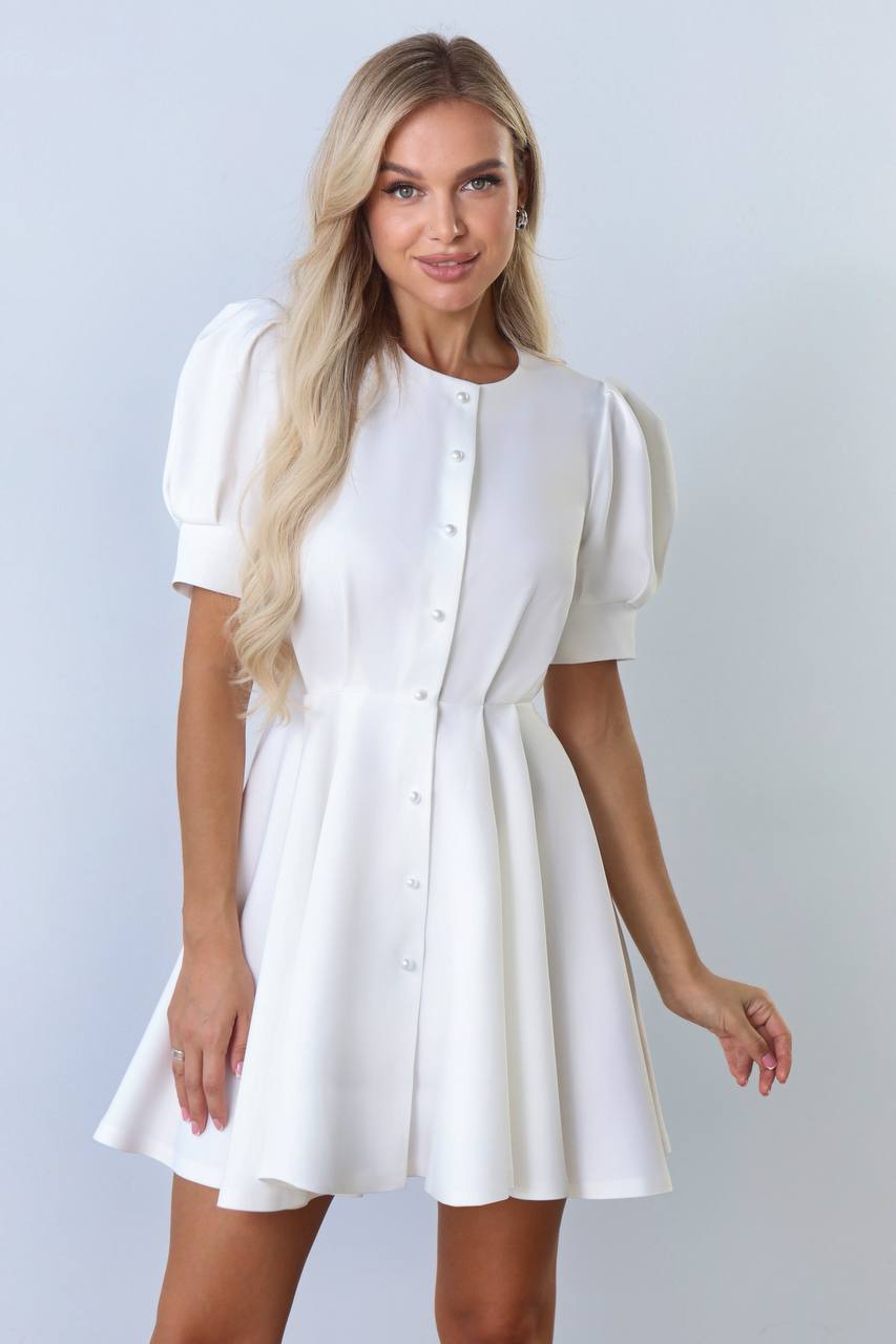 Woman wearing a white dress with a plain background