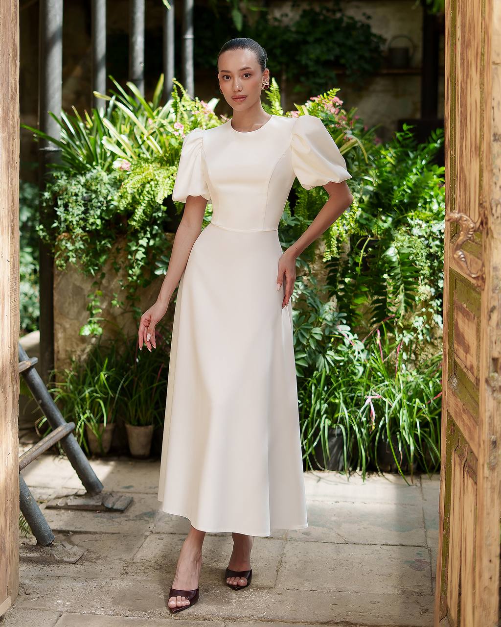 Woman in a white dress standing in a garden setting