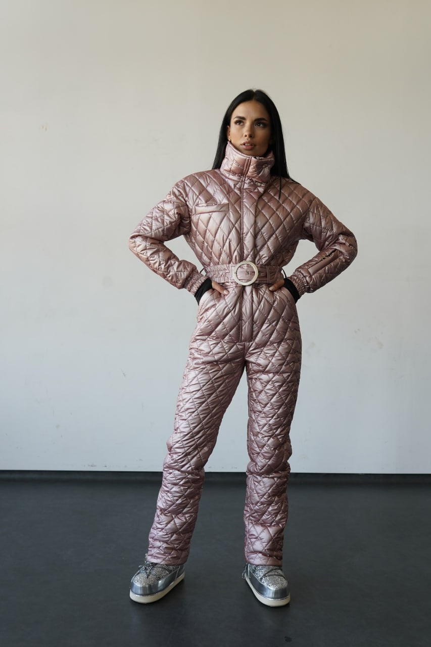 Person wearing a quilted pink snowsuit against a plain background