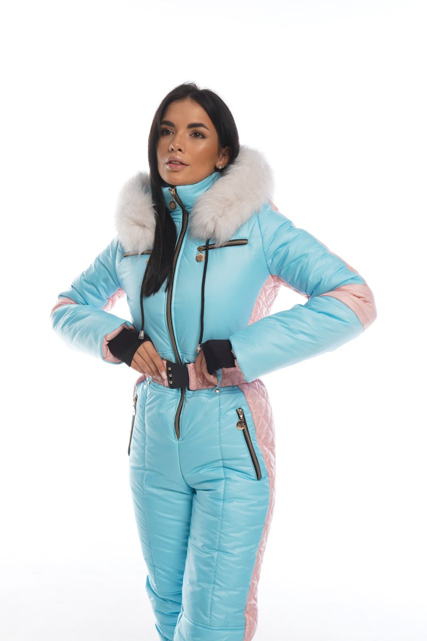 Person wearing a light blue snowsuit with pink accents on a white background