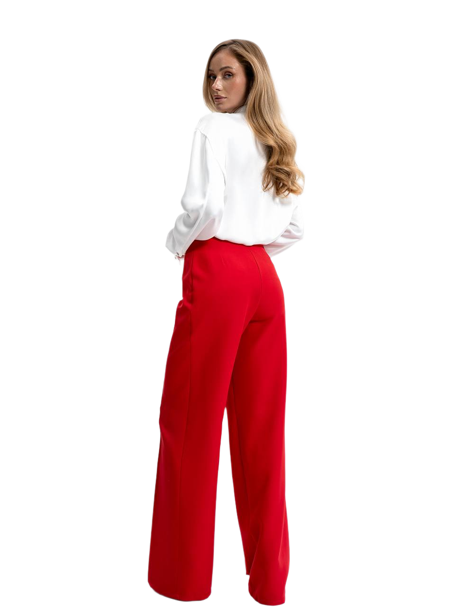 Woman wearing a white blouse and red pants on a white background