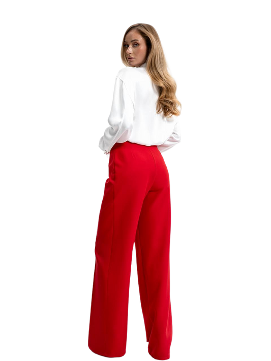 Woman wearing a white blouse and red pants on a white background