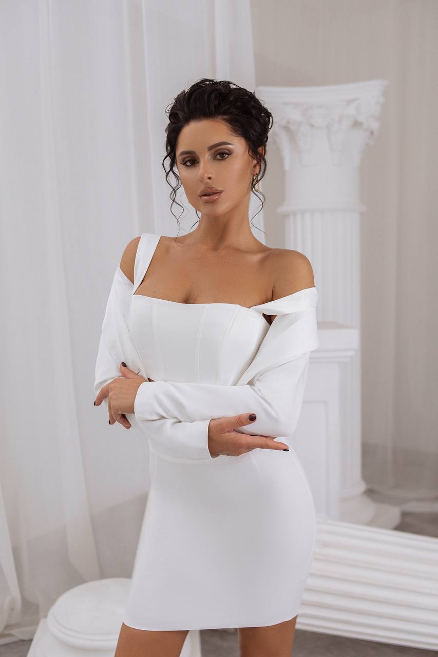 Woman wearing a white off-shoulder dress in a classical setting