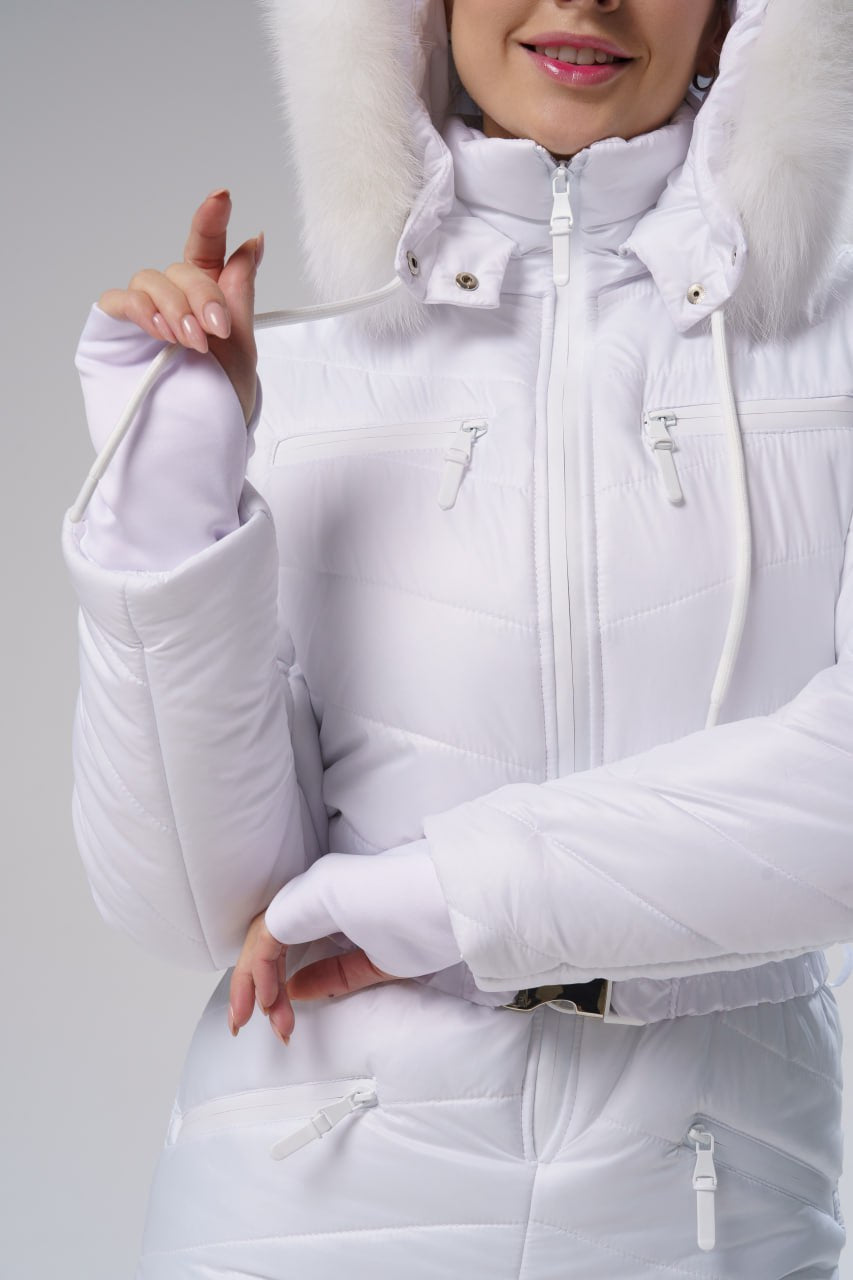 White winter jacket with fur hood worn by a person on a plain background
