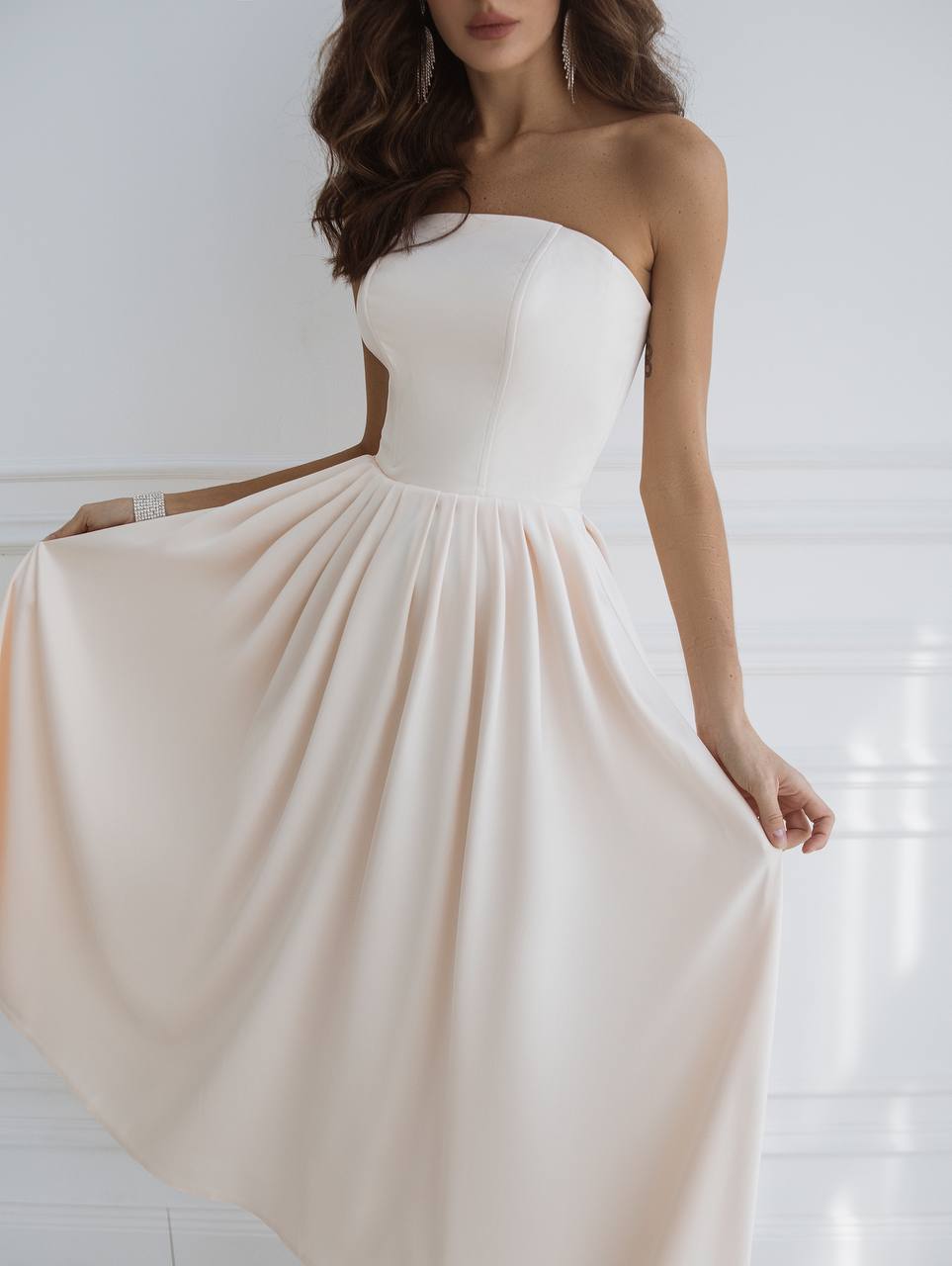 White strapless dress with a flowing skirt on a white background