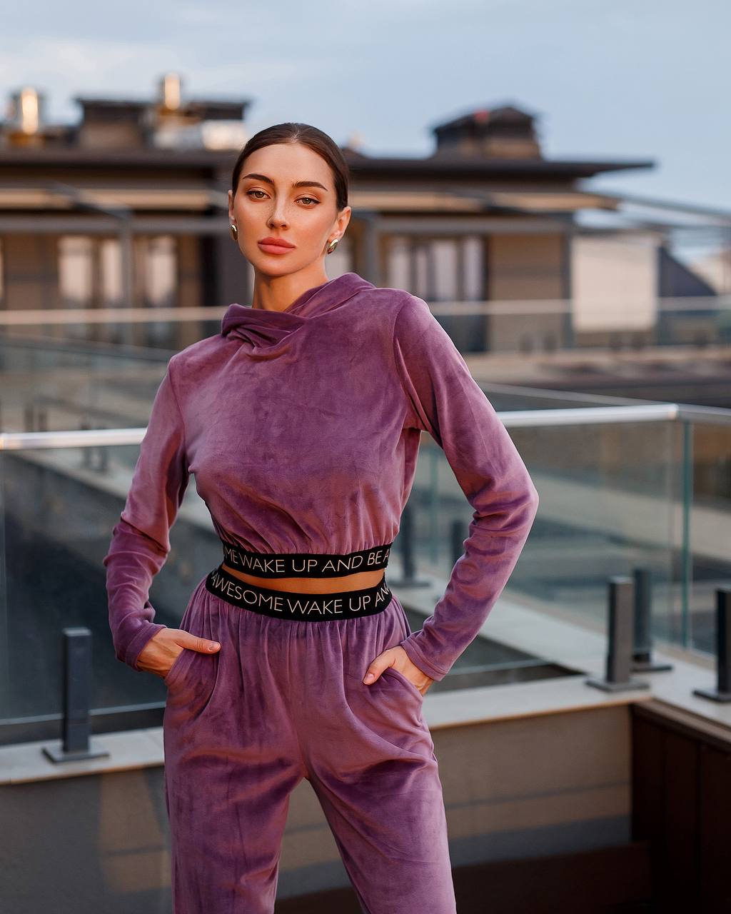 Person wearing a purple outfit with a rooftop background