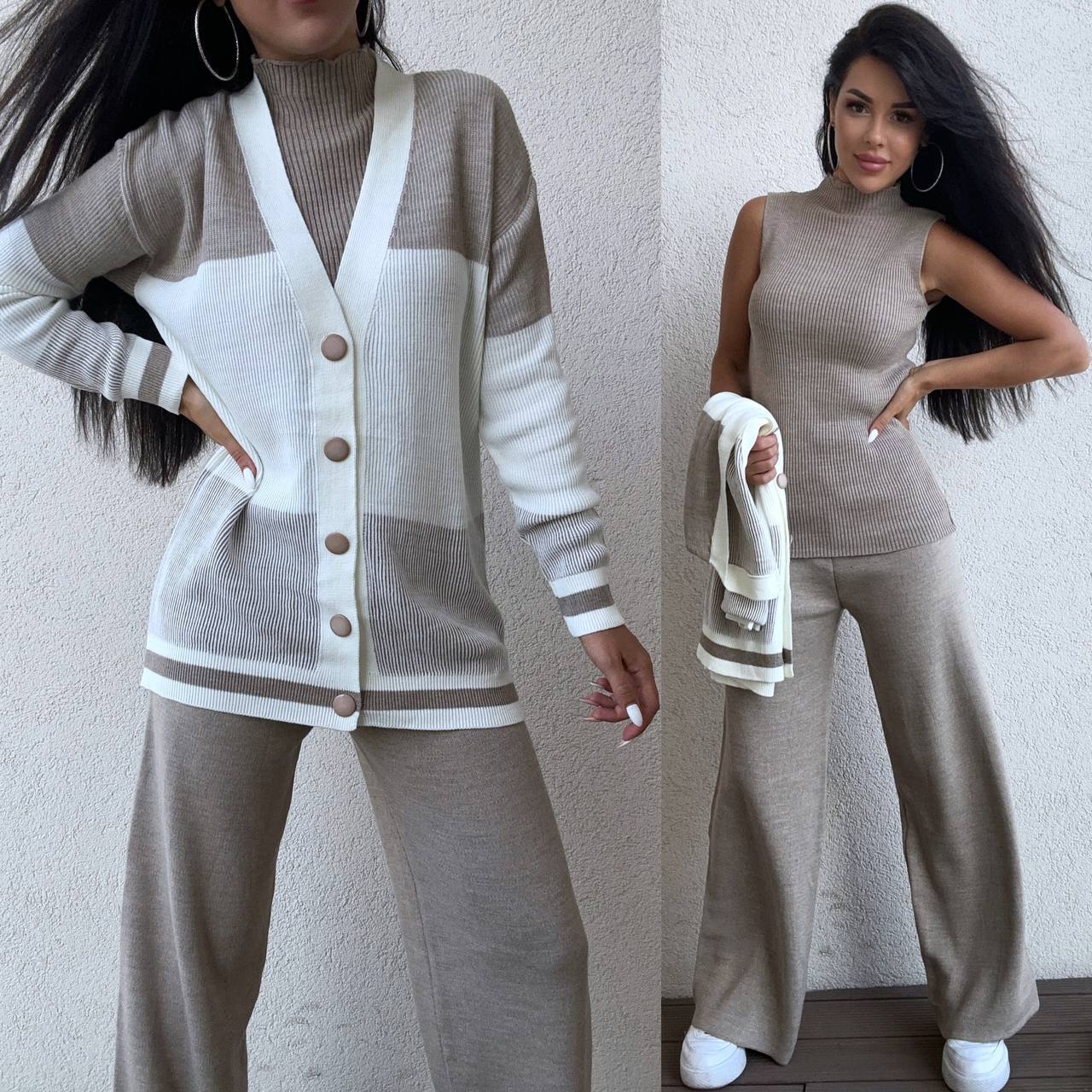 Woman wearing a beige and white cardigan with matching pants, holding a towel.