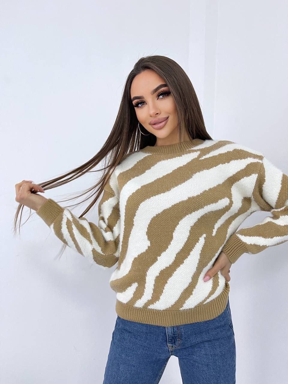 Woman wearing a zebra pattern sweater against a white background