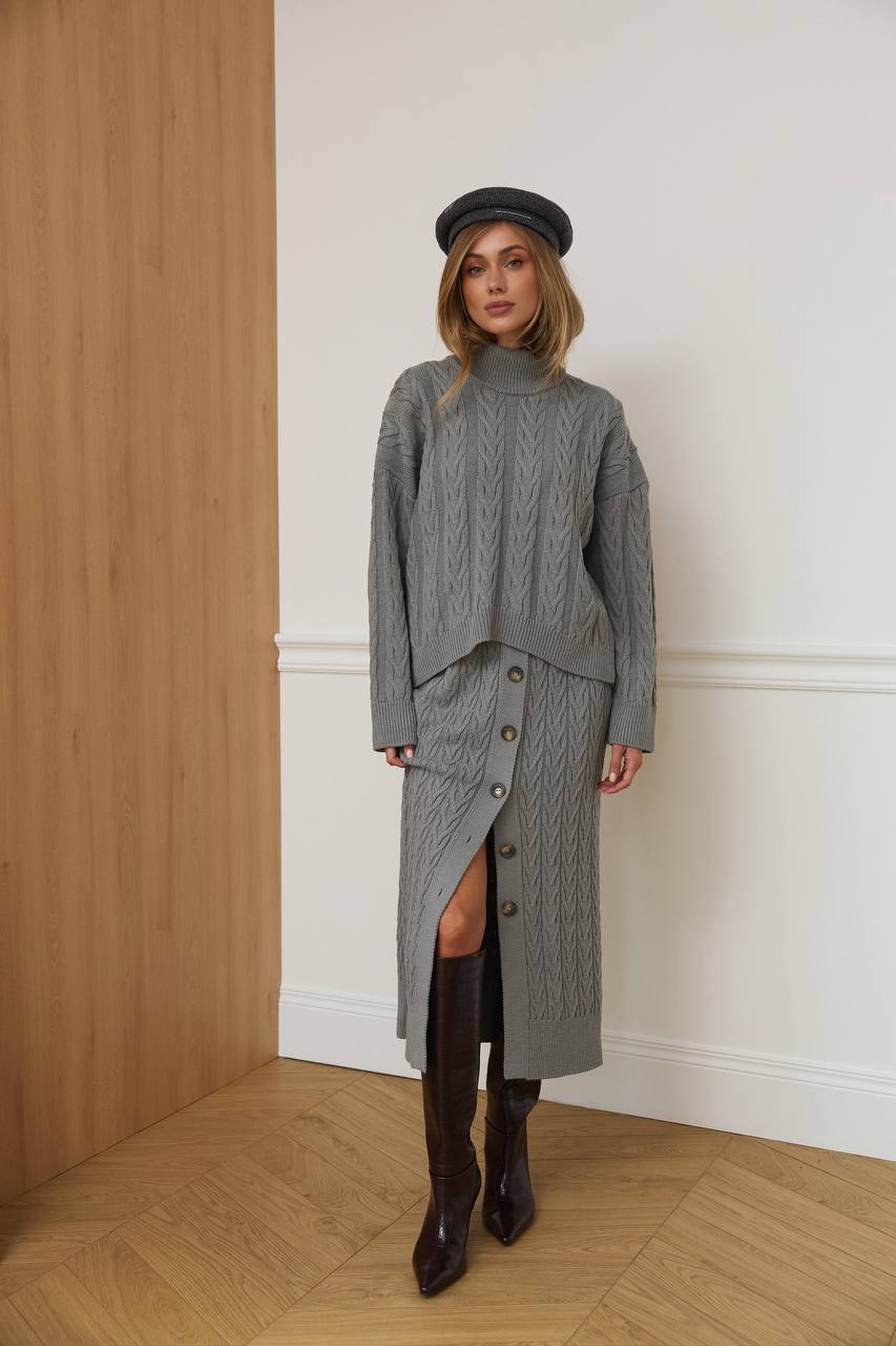 Woman wearing a gray outfit with a hat in an indoor setting