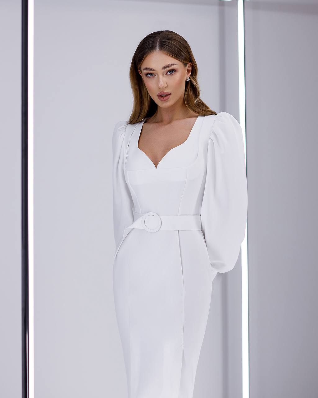 Woman wearing a white dress with a plain background