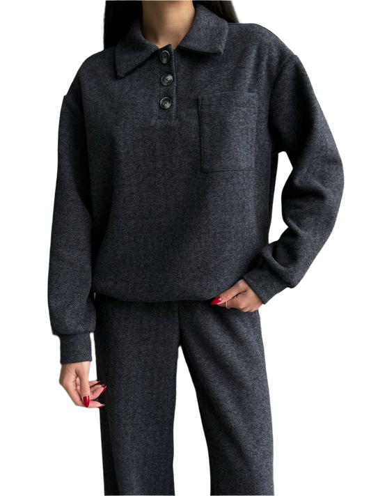 Person wearing a dark gray sweater and pants on a white background
